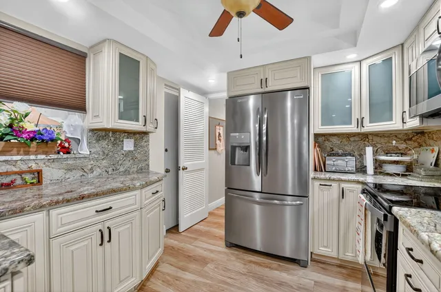 a kitchen with stainless steel appliances granite countertop a sink stove and cabinets
