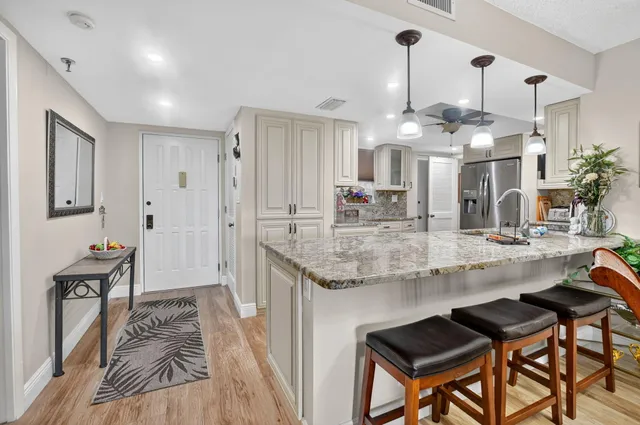 a kitchen with stainless steel appliances granite countertop a sink stove and cabinets
