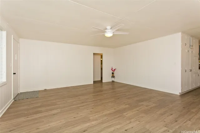 a view of an empty room with wooden floor