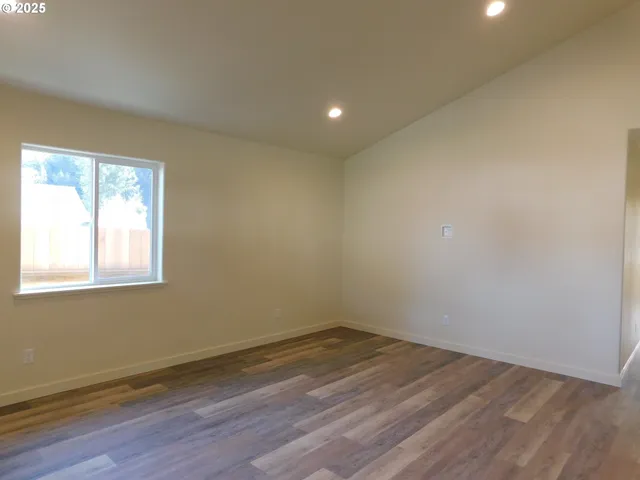 an empty room with wooden floor and closet area