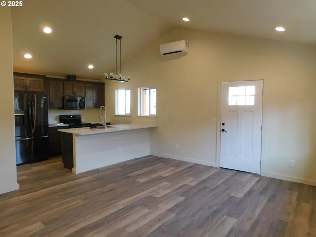 a view of a kitchen with kitchen island a sink stainless steel appliances and cabinets