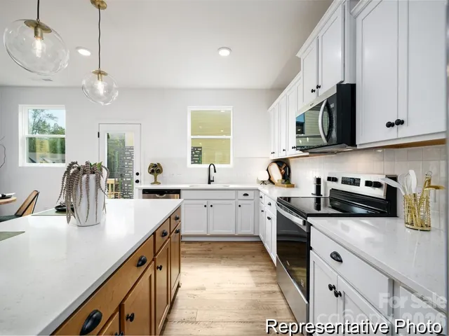 a kitchen with stainless steel appliances granite countertop a sink a stove top oven a counter space and cabinets