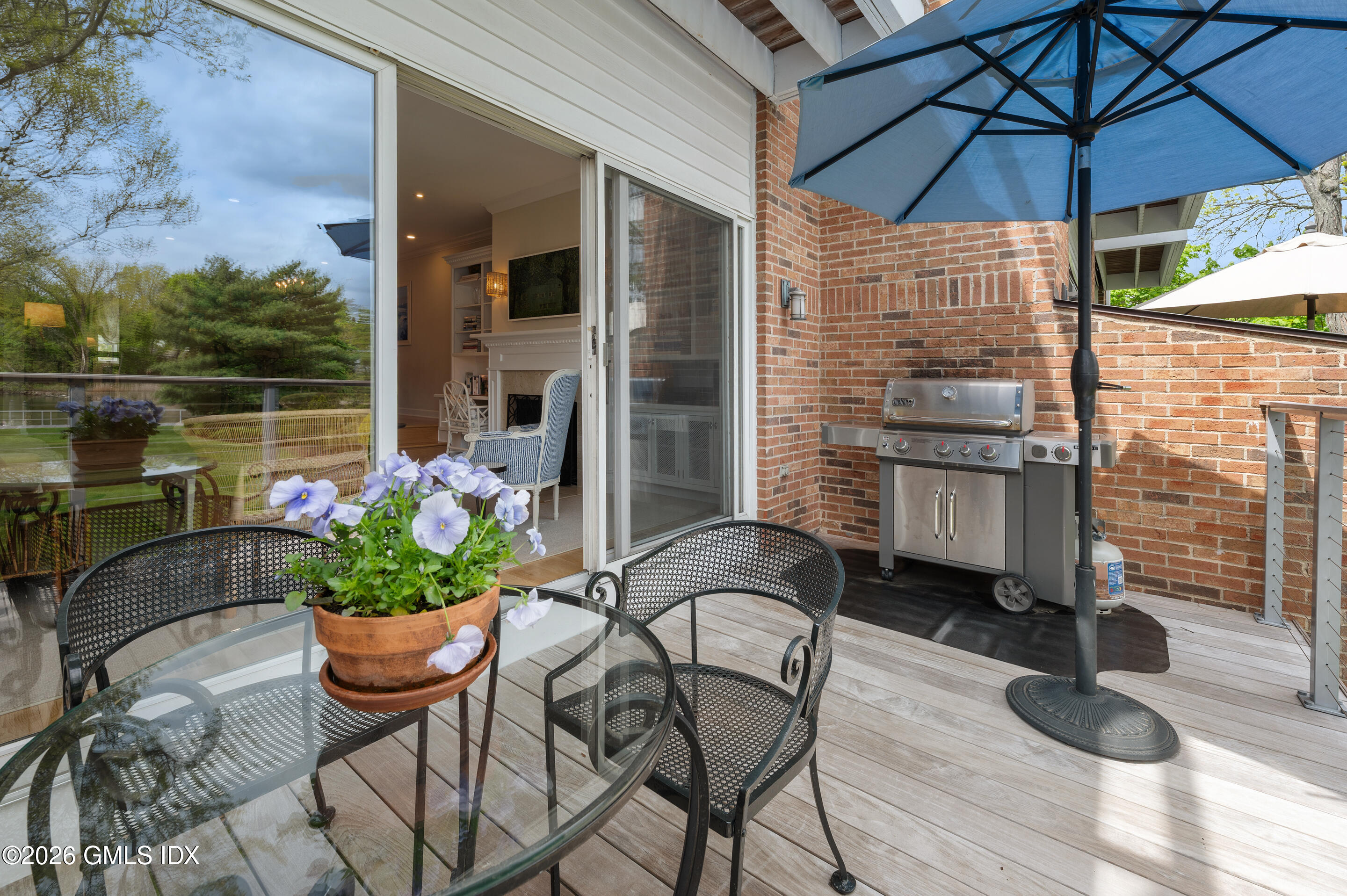 115 River Road, Unit 3 Cos Cob, CT 06807 - Photo 19 of 40 a patio with a table and chairs under an umbrella