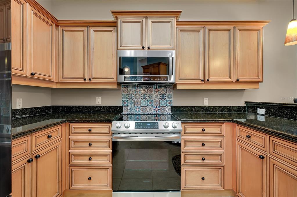 3975 Square E Lane, Unit 9 Sarasota, FL 34238 - Photo 19 of 52 a kitchen with granite countertop white cabinets and stainless steel appliances