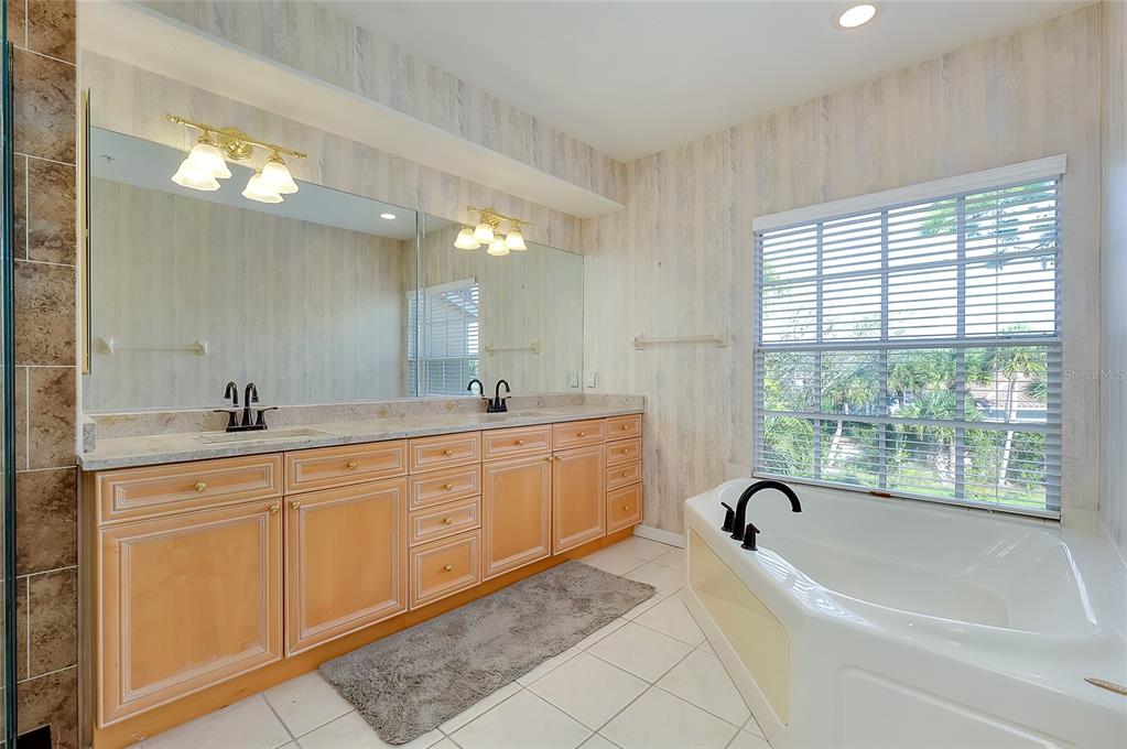 3975 Square E Lane, Unit 9 Sarasota, FL 34238 - Photo 27 of 52 a spacious bathroom with a granite countertop sink mirror and bathtub