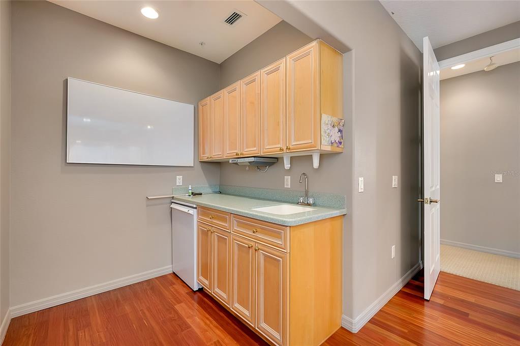 3975 Square E Lane, Unit 9 Sarasota, FL 34238 - Photo 37 of 52 a kitchen with a sink cabinets and wooden floor