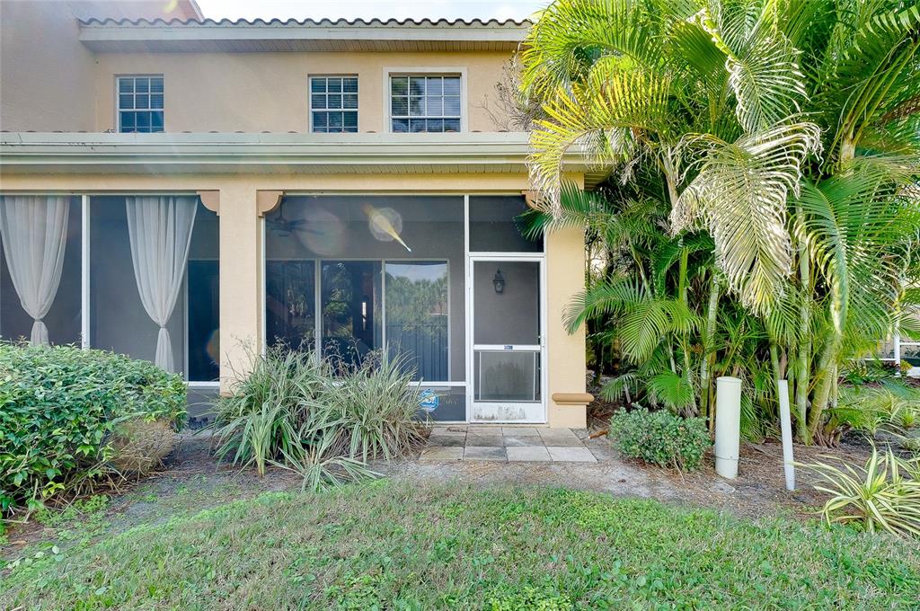 3975 Square E Lane, Unit 9 Sarasota, FL 34238 - Photo 50 of 52 front view of a house with potted plants and a yard