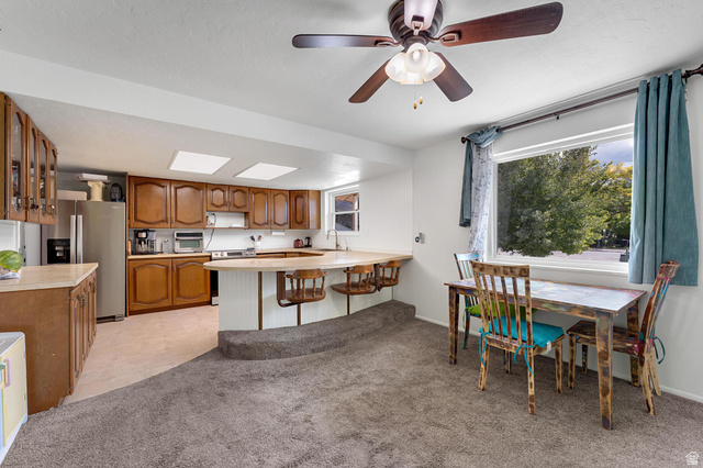 88 West 700 South Payson, UT 84651 - Photo 4 of 27 Kitchen with wood finish cabinets, light countertops, stainless steel appliances, light colored carpet, and a peninsula