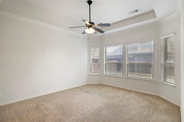 an empty room with closet and a ceiling fan