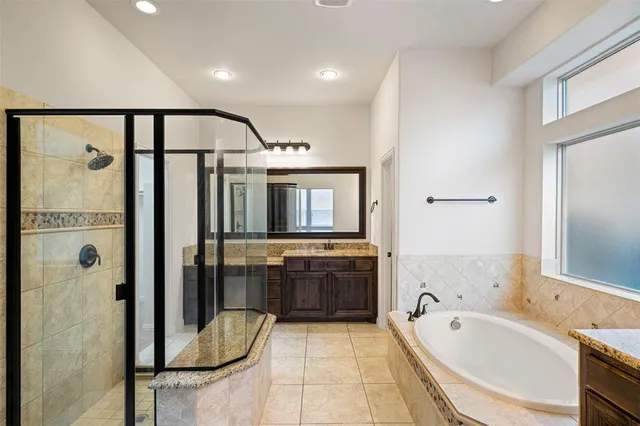 a bathroom with a granite countertop shower a mirror and a sink