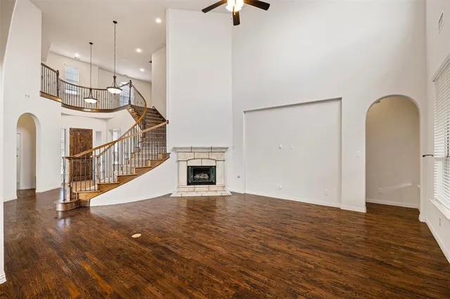 a living room with stainless steel appliances kitchen island granite countertop a stove and a wooden floor