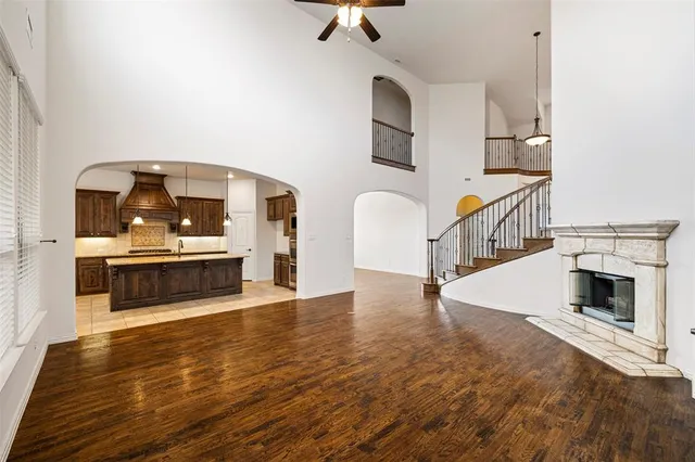 a view of a living room with kitchen island wooden floor and kitchen
