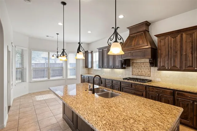 a kitchen with kitchen island granite countertop wooden cabinets and a stove