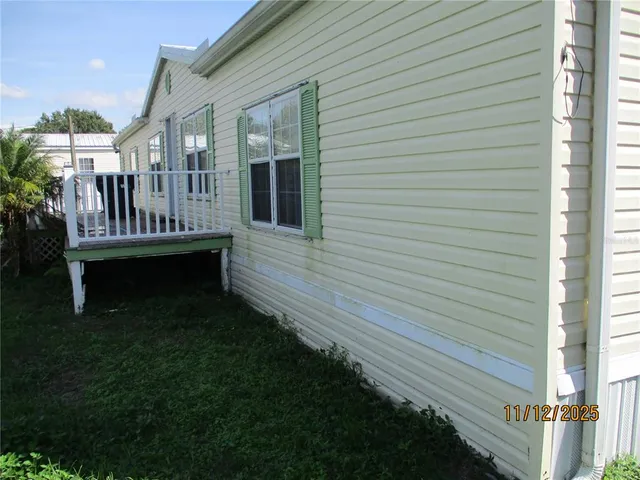 a view of a house with a wooden deck and a yard