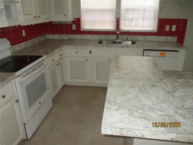 a kitchen with granite countertop a sink and a stove