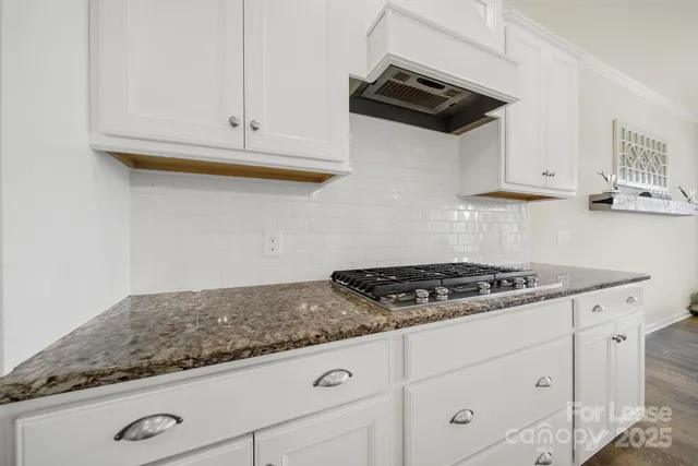 a kitchen with white cabinets and appliances