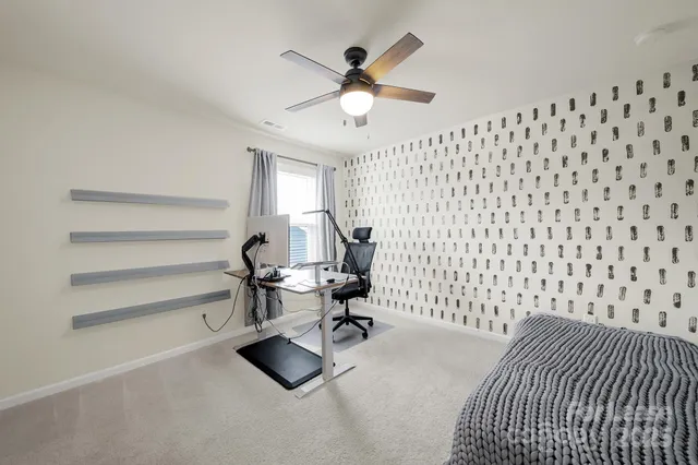 a bedroom with a bed and a flat screen tv with wooden floor