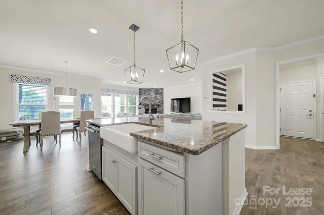 a kitchen with stainless steel appliances granite countertop living room and couches with wooden floor