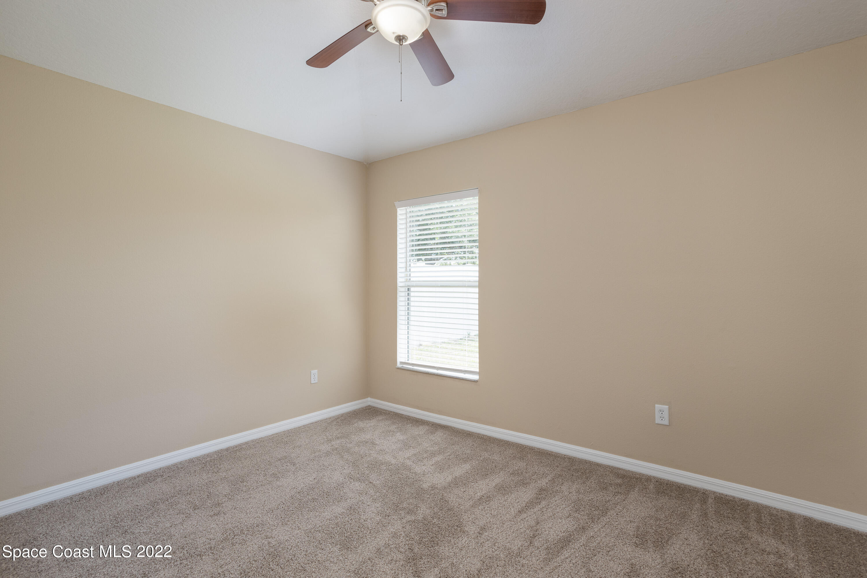 2400 Bridgeport Circle Rockledge, FL 32955 - Photo 20 of 31 an empty room with a chandelier fan and windows