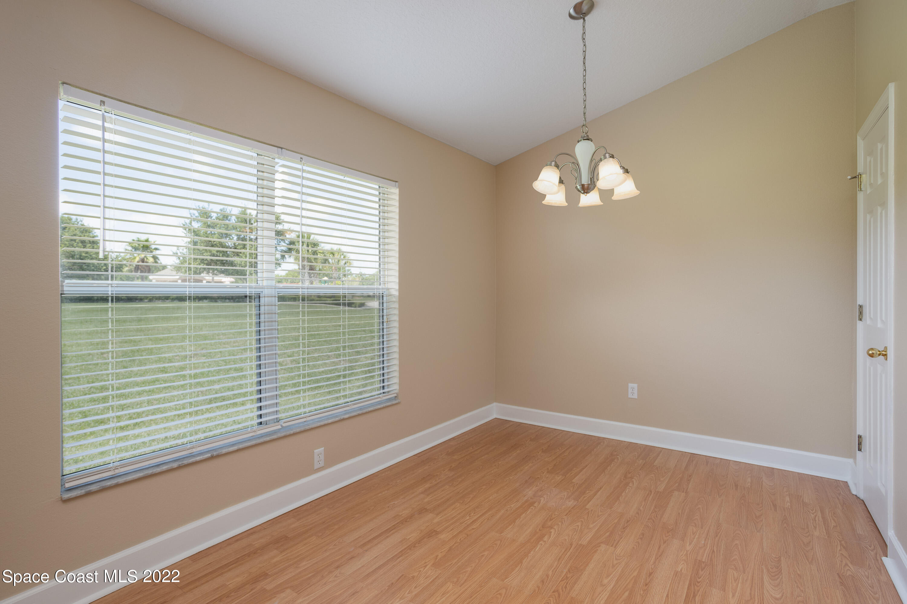 2400 Bridgeport Circle Rockledge, FL 32955 - Photo 7 of 31 a view of an empty room with wooden floor and a window