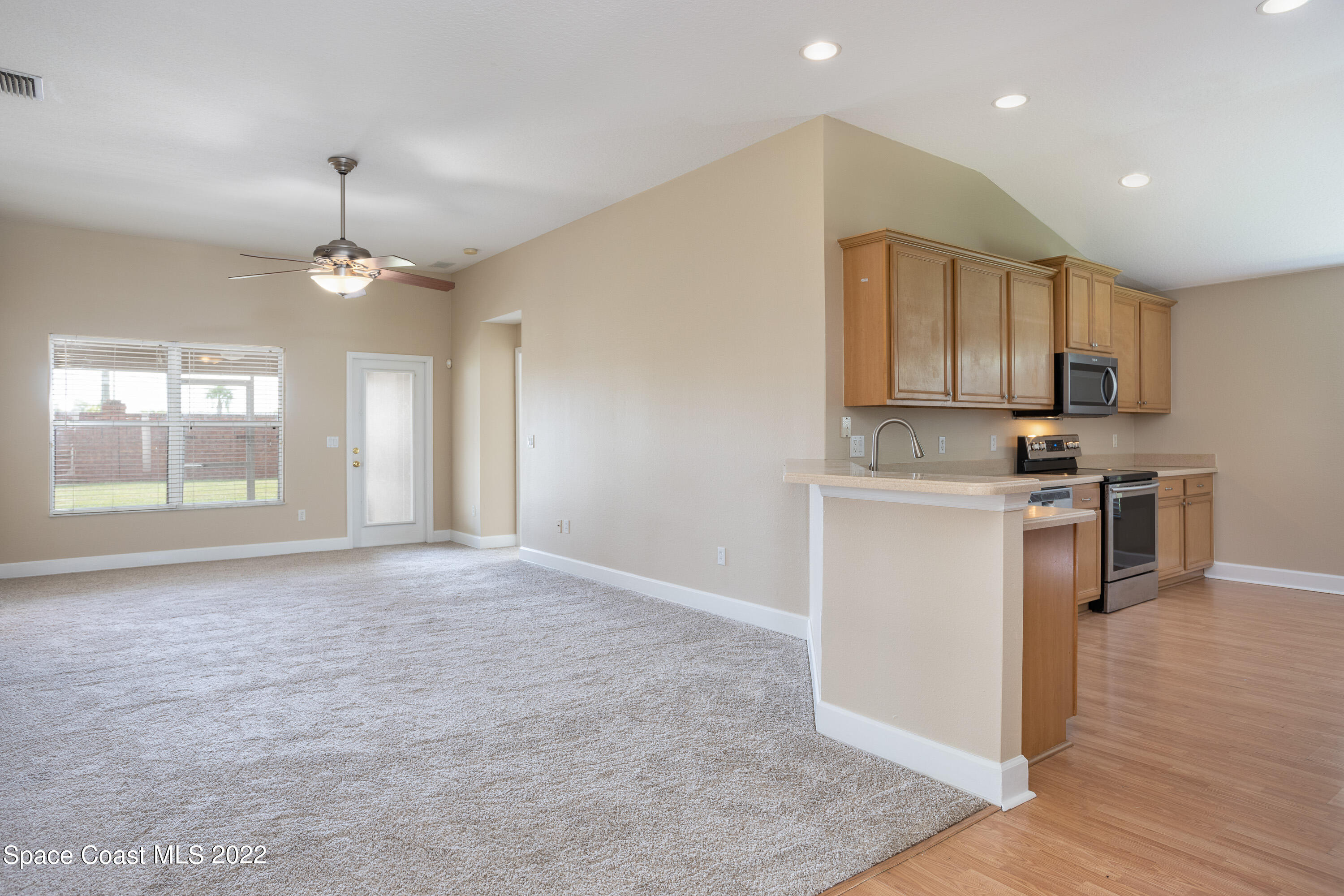 2400 Bridgeport Circle Rockledge, FL 32955 - Photo 8 of 31 a kitchen with kitchen island granite countertop a stove a sink a center island and cabinets