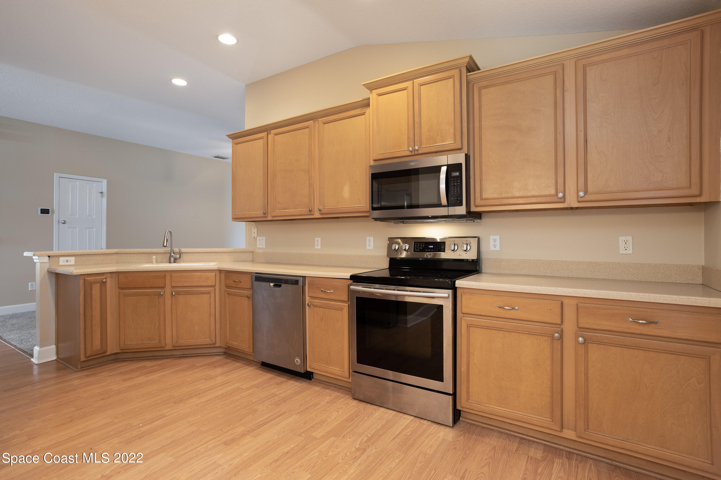 2400 Bridgeport Circle Rockledge, FL 32955 - Photo 9 of 31 a kitchen with granite countertop white cabinets stainless steel appliances and a sink