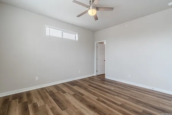 a view of wooden floor and a chandelier fan in a room