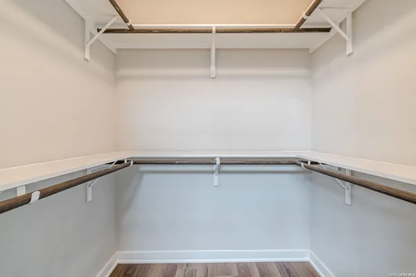 a view of walk in closet with empty racks