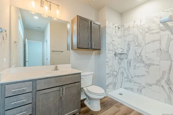 a bathroom with a toilet sink and mirror