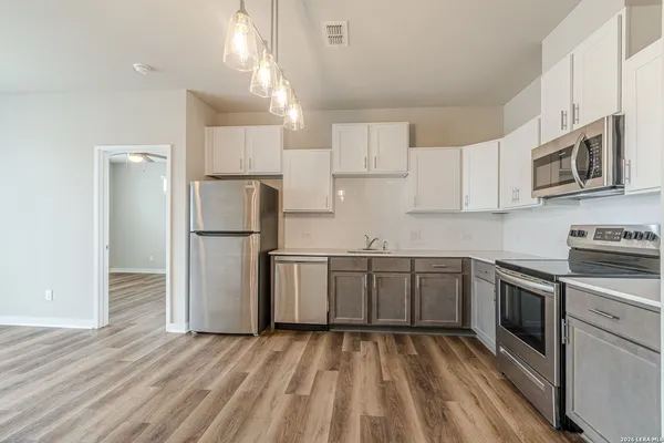 a kitchen with cabinets stainless steel appliances and a counter space