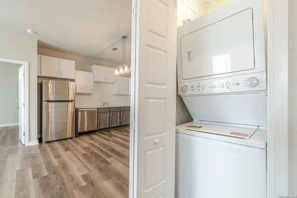 a view of a kitchen with refrigerator and wooden floor