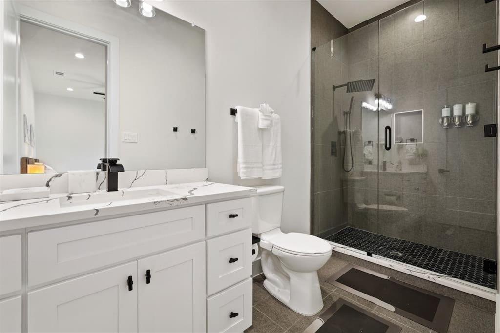 5942 Prospect Avenue Dallas, TX 75206 - Photo 15 of 25 Full bathroom featuring vanity, a shower stall, recessed lighting, and dark tile patterned floors