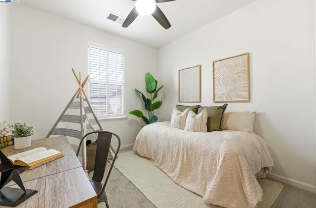 a bedroom with a bed a couch and a potted plant