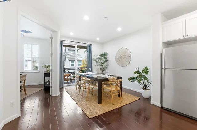 a living room with furniture a large window and wooden floor