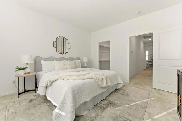 a bedroom with a bed and painting on the wall