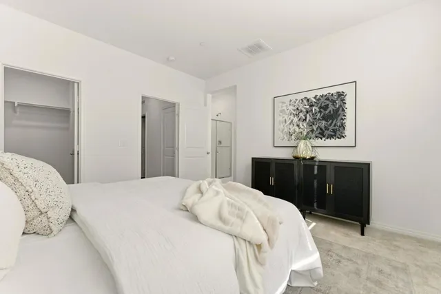 a bedroom with a bed and a painting on the wall