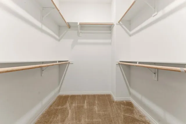 a view of walk in closet with empty racks