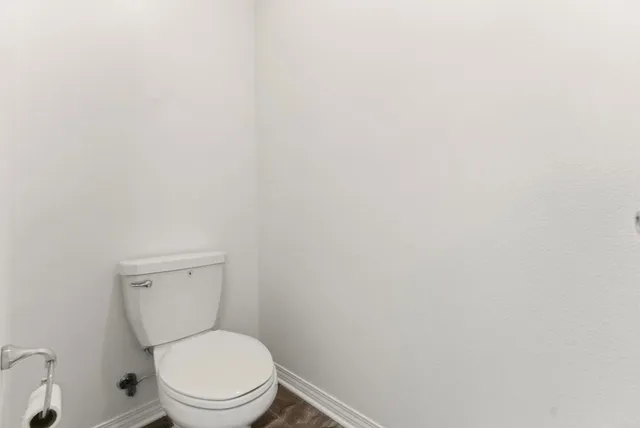 a white toilet sitting next to a white sink and vanity