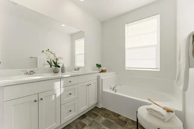 a bathroom with a bathtub sink and mirror