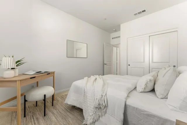 a bedroom with a bed and a table chair