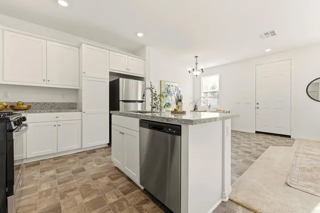 a kitchen with a sink refrigerator and cabinets