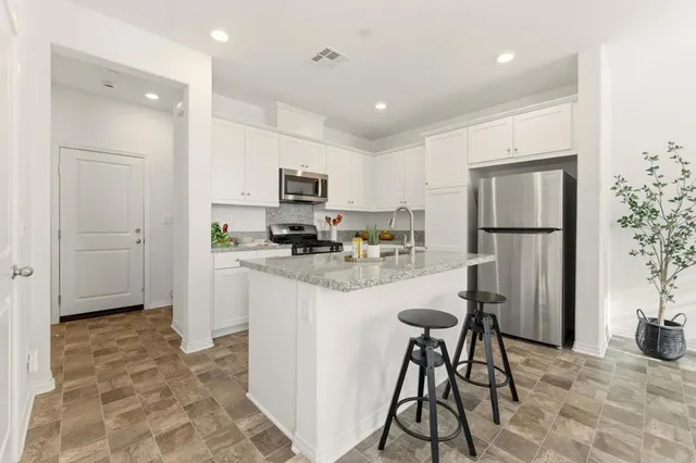 a kitchen with refrigerator and cabinets