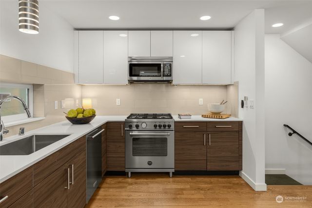 a kitchen with stainless steel appliances granite countertop a sink a stove and a cabinets