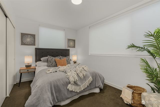 a bedroom with a bed and a potted plant