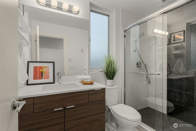 a bathroom with a granite countertop sink toilet a mirror and shower