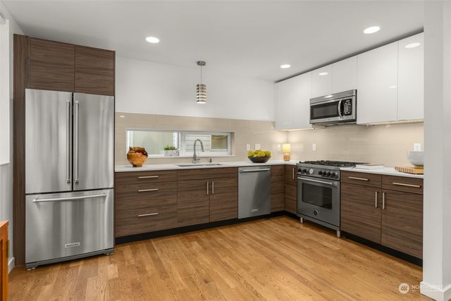a kitchen with granite countertop stainless steel appliances and wooden cabinets