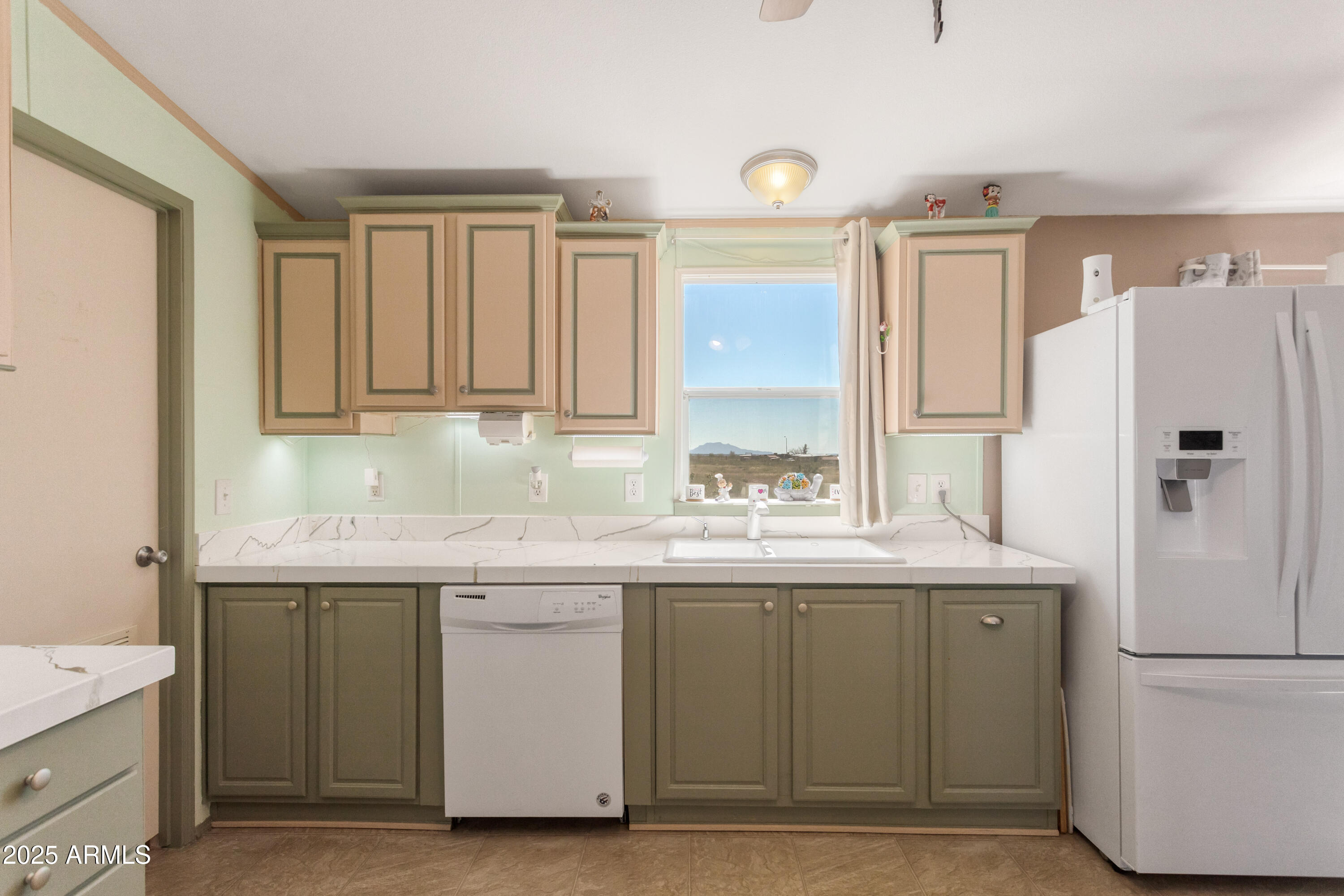 1907 East Vía Ocotillo Douglas, AZ 85607 - Photo 7 of 49 a kitchen with a sink a refrigerator and cabinets