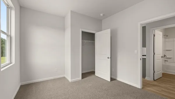 an empty room with windows and closet