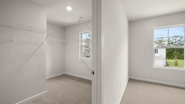an empty room with windows and closet