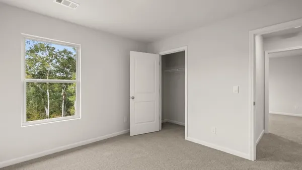 an empty room with windows and closet